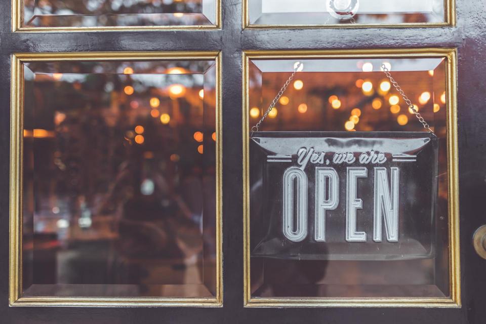 open sign hanging in window of storefront