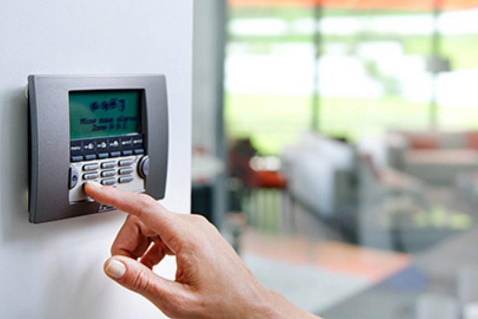 close up of alarm panel with person pushing buttons