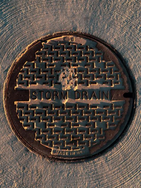 metal manhole cover on gray pavement