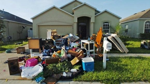 House with pile of junk and debris in front of it
