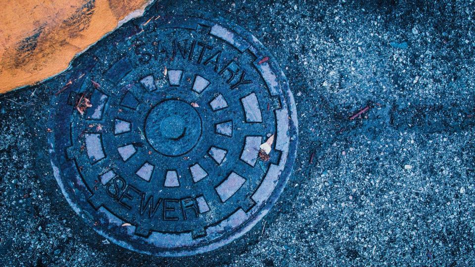 Blue manhole cover on pavement