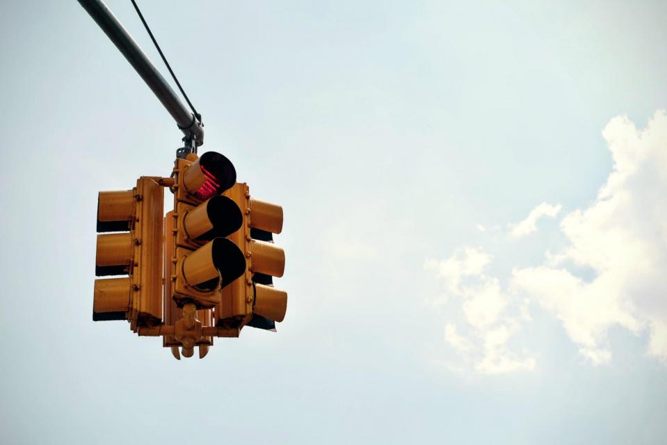 yellow four way traffic signal against cloudy sky