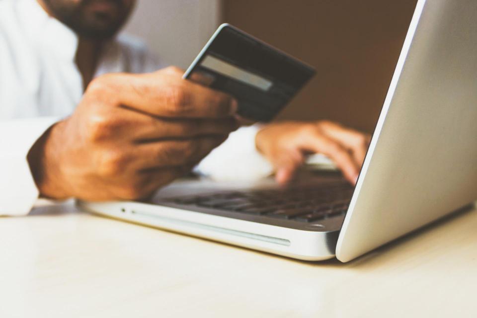 person entering credit card information into computer